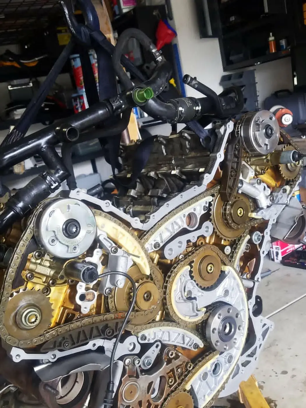 The back of a V8 engine on a stand, timing chains and cam adjusters in view